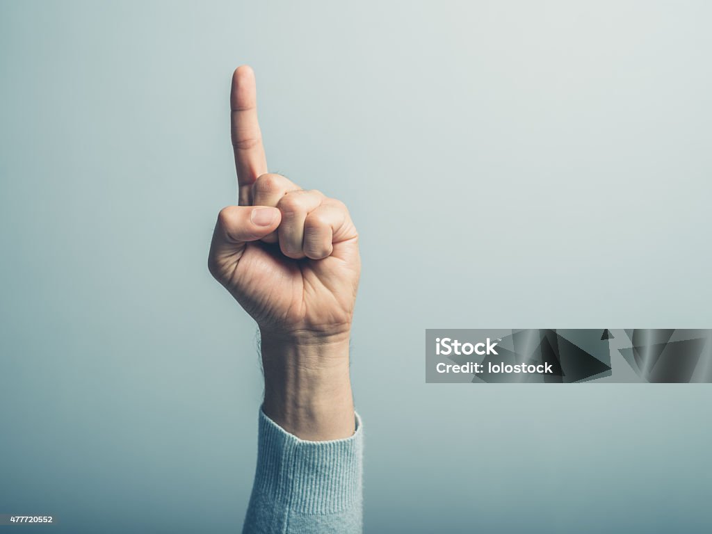 Male hand with finger pointing up A male hand with the index finger pointing up Number 1 Stock Photo