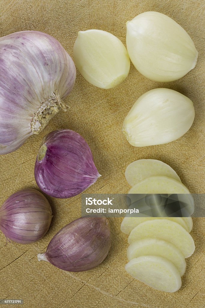garlic garlic bulb with garlic cloves and garlic slices on wooden cutting board. Chopping Food Stock Photo
