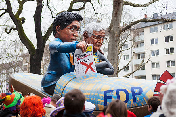 Rose Monday Carnival Parade Mainz 2014 Mainz, Germany - March 3, 2014: A so called Motivwagen with huge caricatural figures dealing with german social or political issues - in this particular case with the German FDP - Freie Demokratische Partei. In the back- and foreground many spectators. Rosenmontagszug in Mainz is one of the largest and most famous carnival parades in Germany with approx. 500.000 spectators german free democratic party photos stock pictures, royalty-free photos & images