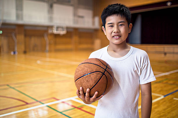 istock Japanese school boy playing basketball 477723238