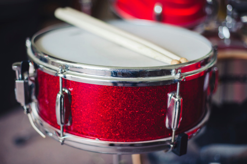Close up image of percussion snare drum and sicks.
