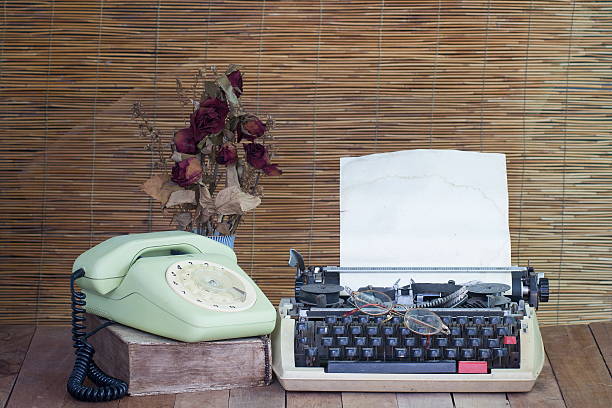 istock Still life with old typewriter telephone book with dry rose 477725864