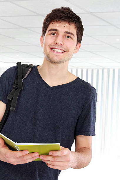 istock Young male college student with books 477726404