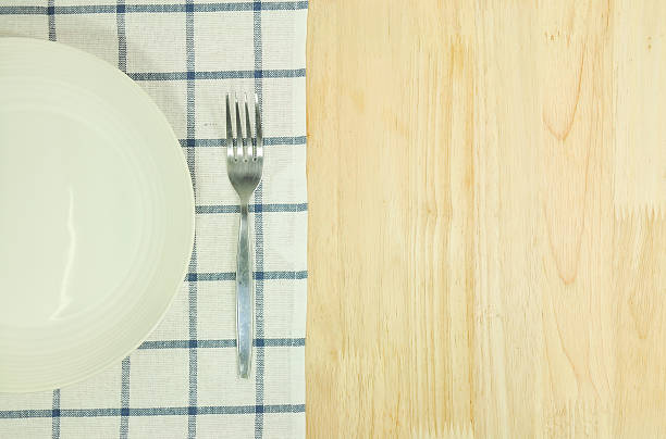 istock plate and fork with tablecloth on white wooden table and copyspace. 477732268