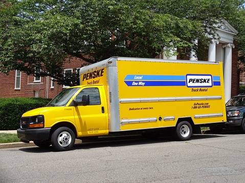 Washington DC, USA-June 16, 2015:  This yellow Penske Truck was spotted in a Northwest Cleveland Park neighborhood in Washington DC.  The driver is most likely using the truck to move into an apartment.  Penske Truck Rental was founded in 1969 by Rodger Penske and has 2000 locations in the USA and Canada.