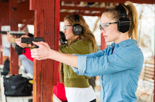 A woman practicing at the gun range. Photographed on location at a shooting range.