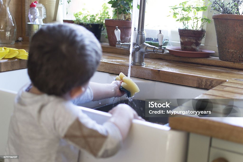 Washing up A young child helping to wash up 12-17 Months Stock Photo