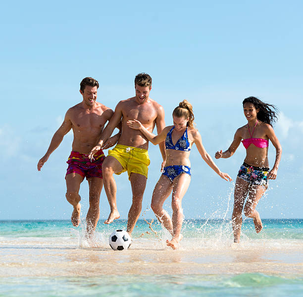 istock Young People Playing Football On The Beach 477737357