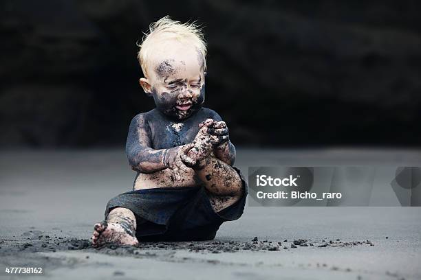Portrait Of Dirty Child On The Black San Beach Stock Photo - Download Image Now - Dirty, Baby - Human Age, Unhygienic