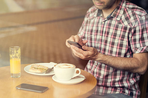 istock Male using cell phone in a coffee shop 477739010