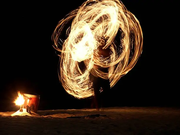 Long Exposure Image. Fire Dancer Creating Ring Shape with Fire Outdoors at Night