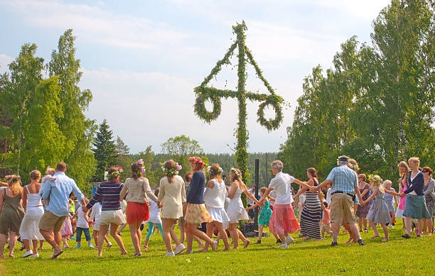 Dance around Midsummer pole Akersberga, Stockholm, Sweden - June 21, 2013: Summer dressed beautiful people dance in a traditional ring around the birch leaf clad Midsummer pole at Summer Solstice on June 21, 2013 in Akersberga, Stockholm, Sweden summer solstice stock pictures, royalty-free photos & images