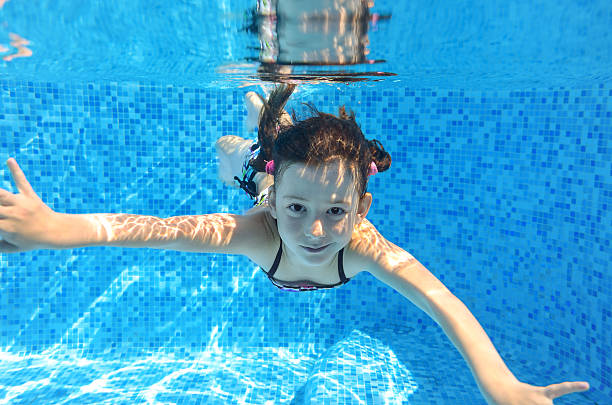 istock Happy active child swims underwater in pool 477743097