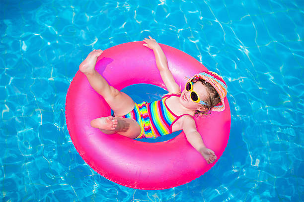 istock Cute little girl playing in swimming pool 477749006