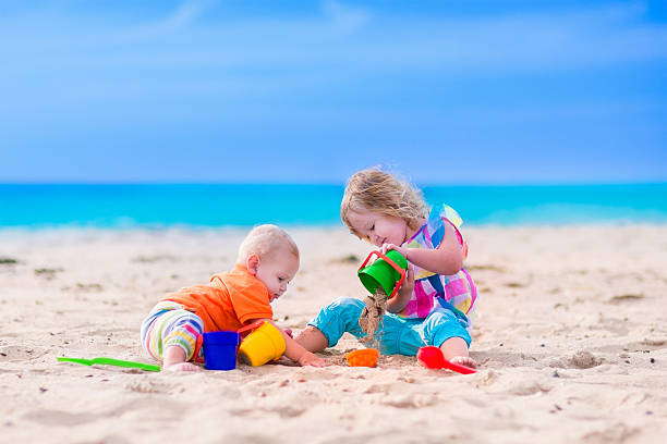 istock Little kids building a sand castle on a beach 477749008