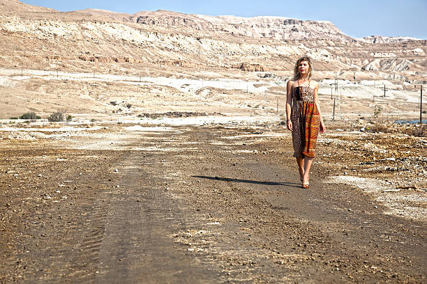 istock Woman walking in the dessert 477749564
