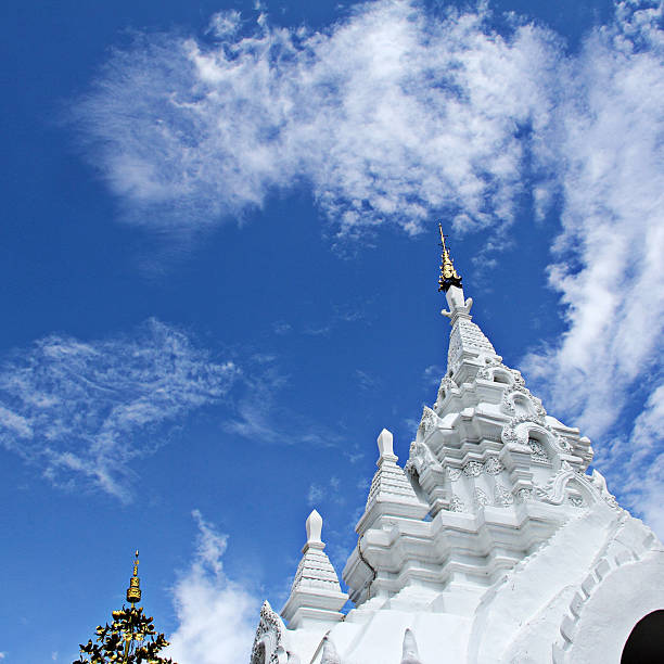 istock White stucco thai buddhist temple with cloud and blue sky 477753138
