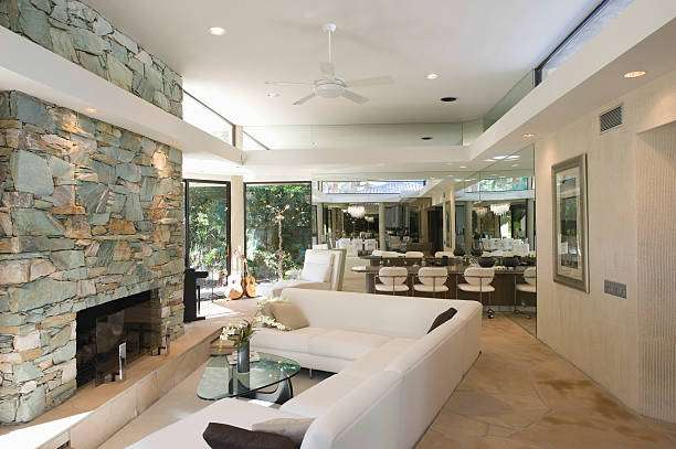 Seating Area And Stone Fireplace Sunken seating area and stone fireplace with dining area in background at home sunken stock pictures, royalty-free photos & images