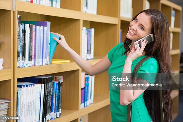 Student Using Her Phone In Library Stock Photo - Download Image Now - Book, Holding, Library
