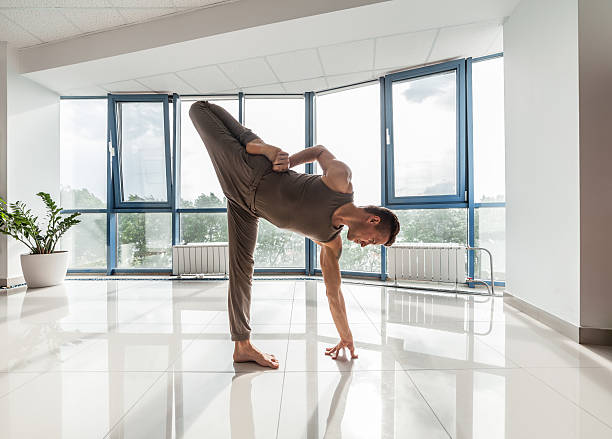 istock Man training yoga at the gym 477754914