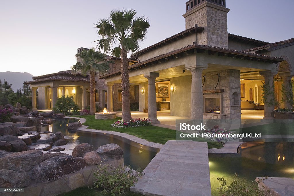 Illuminated House With Pond In Foreground View of an illuminated modern house with pond in foreground Outdoors Stock Photo