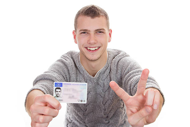 istock Young man showing his driver license 477757083