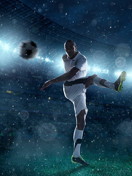 istock Soccer player kicks a ball on stadium 477757151