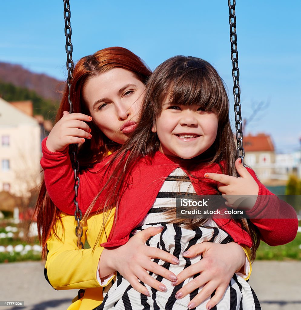 happy family excited little girl with her mother in park on swing, happy lifestyle, summer outdoor activities. 2015 Stock Photo