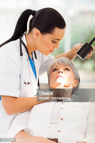 Dermatologist Inspecting Middle Aged Patients Skin Stock Photo - Download Image Now