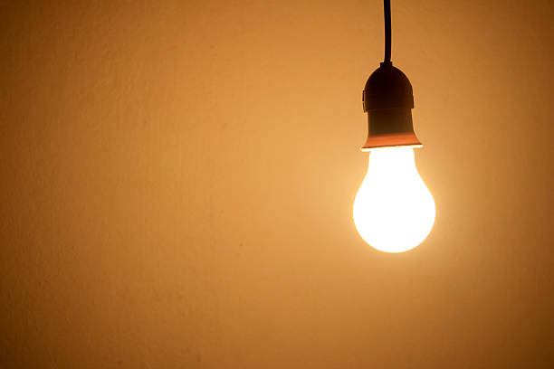 istock Lightbulb Lamp orange light in room at night 477772950