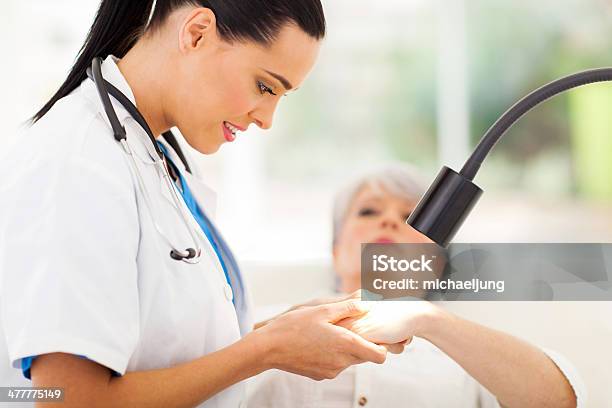 Dermatologist Examining Senior Womans Skin Stock Photo - Download Image Now - Dermatologist, Dermatology, Doctor