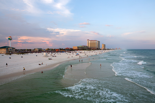 Pensacola, Florida, USA - May 19, 2015. Beach goers spend the last available minutes of daylight enjoying the sand and the surf.