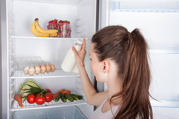 istock Woman chosen milk in opened refrigerator 477777600