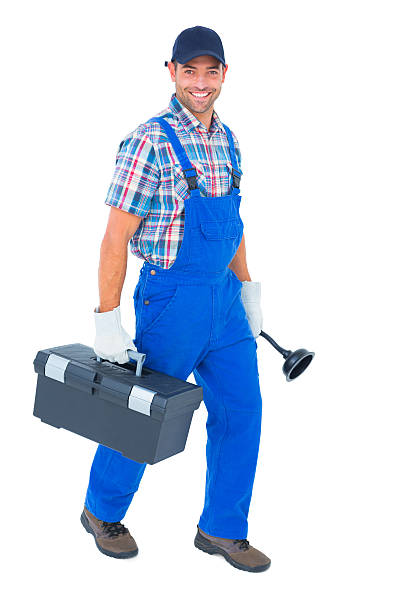 Full length portrait of happy plumber with plunger and toolbox walking on white background