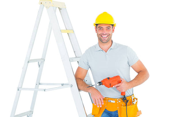 istock Happy handyman with power drill leaning on ladder 477777964