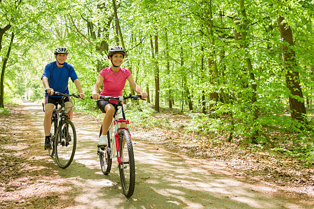 Active mature couple outdoors riding bikes in the nature