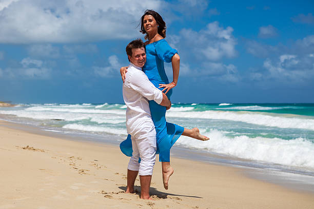 istock Guy holds girl on hands. Ocean beach 477785786