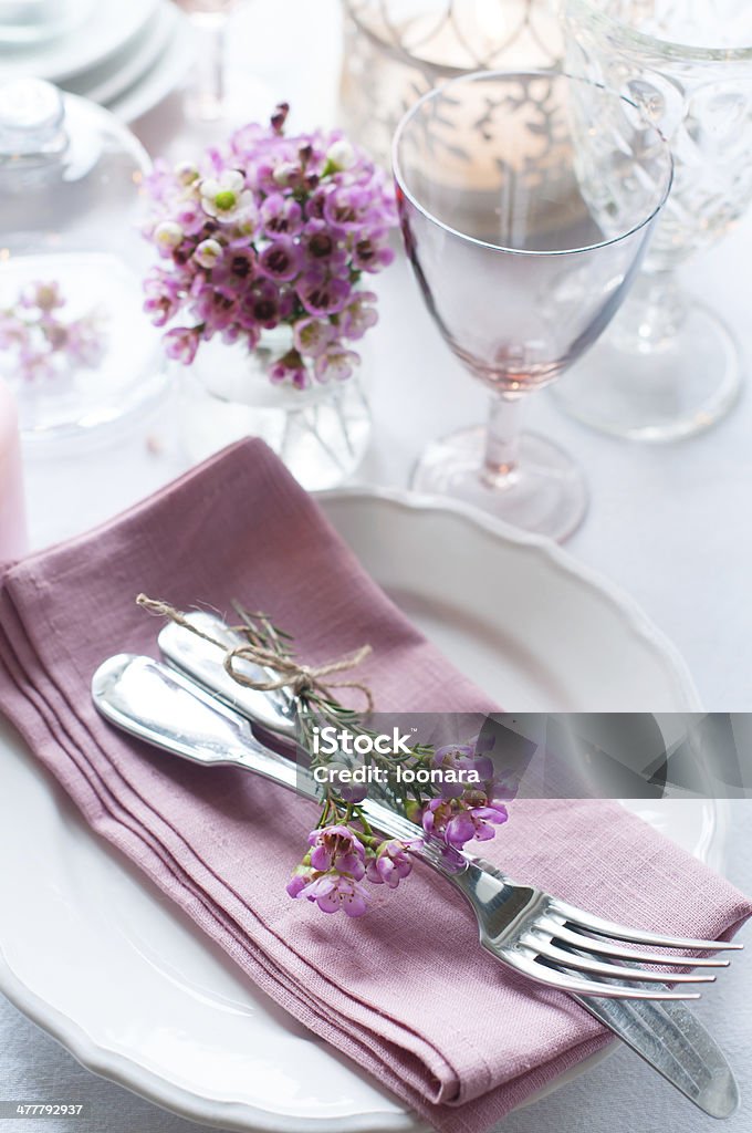 Festive wedding table setting Festive wedding table setting with pink flowers, napkins, vintage cutlery, glasses and candles, bright summer table decor. Arrangement Stock Photo