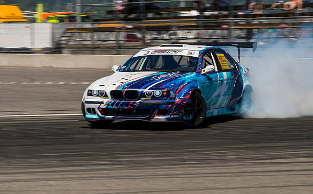 Drift car overcome turn track Lviv, Ukraine - June 6, 2015: Unknown rider on the car brand BMW overcomes the track in the championship of Ukraine drifting in Lviv. snowdrift photos stock pictures, royalty-free photos & images