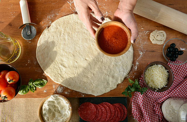 istock woman hands cooking pizza at home 477794592
