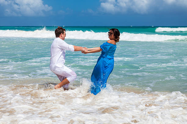 istock Beach couple have a fun in the waves. 477795636