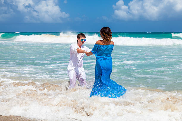 istock Beach couple have a fun in the waves. 477795640