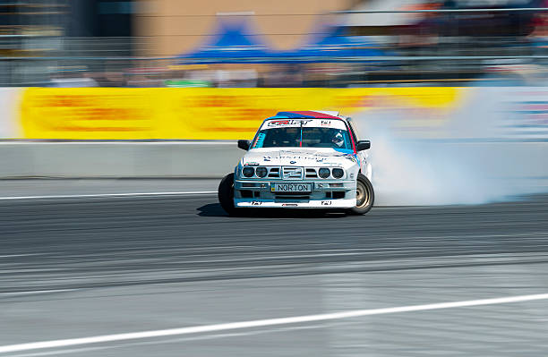 Blurry action shot of a car drifting through an empty lot at night, with lights creating streaks in the dark. Blur and graininess emphasize the motion and urban atmosphere, cinematic motorsport