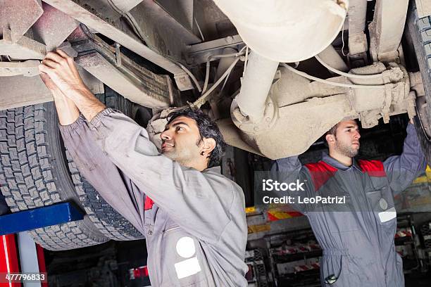 Mechanics Working Below A Truck Stock Photo - Download Image Now - Truck, Below, Repairing