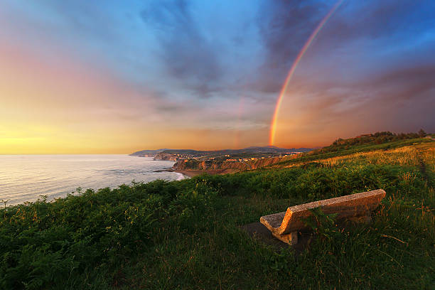 Bench near Sopelana coast with rainbow Bench near Sopelana coast with rainbow and stormy weather sopelana stock pictures, royalty-free photos & images
