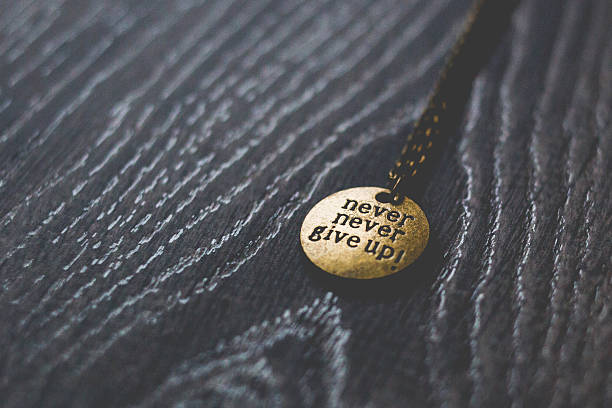 istock Round brass pendant with words never give up 477807582
