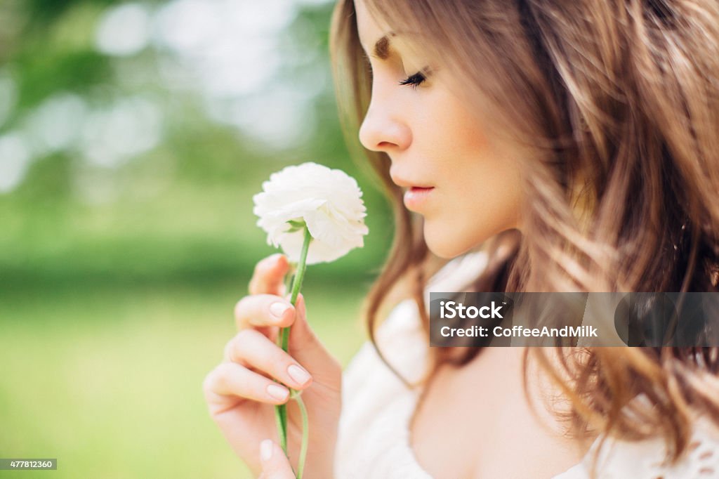 Linda mulher segurando uma flor em sua mão - Foto de stock de Mulher bonita royalty-free