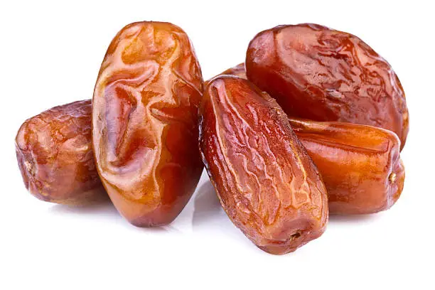 close up of dried dates on white background