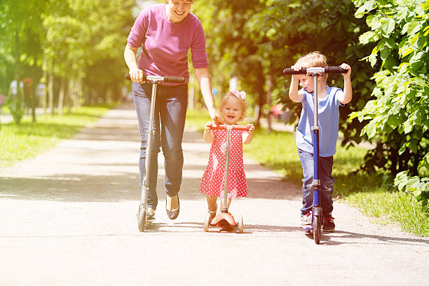 istock mother with kids riding scooter in summer 477812544