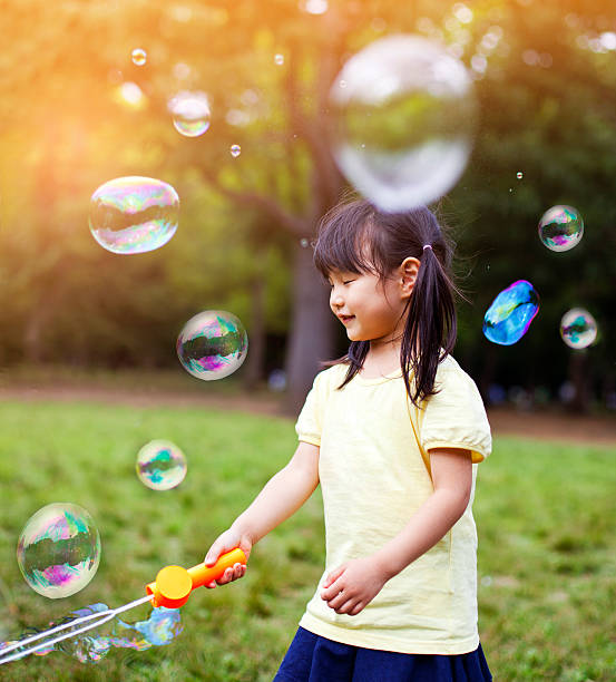 istock Little girl blowing soap bubbles 477815514